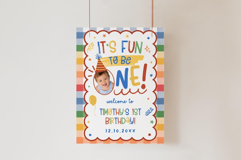 Puede incluir: Un cartel de cumplea&ntilde;os rectangular con un borde a cuadros de colores que incluye el texto IT'S FUN TO BE ONE! welcome to TIMOTHY'S 1ST BIRTHDAY! 12.10.20XX. El dise&ntilde;o incluye una foto circular de un beb&eacute; con gorro de fiesta y estrellas.