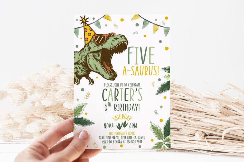 Może przedstawiać: Zaproszenie urodzinowe z kresk&oacute;wkowym dinozaurem w okularach przeciwsłonecznych i czapce imprezowej. Tekst brzmi "FIVE A-SAURUS!" i ogłasza 5. urodziny Cartera 4 listopada o 15:00. Projekt zawiera liście i konfetti.