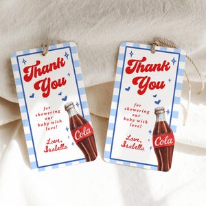 Może przedstawiać: Dwie prostokątne etykiety na prezenty z niebiesko-białą kratką. Etykiety zawierają napis "Thank You" w czerwonym skrypcie, z tekstem "for showering our baby with love!" i "Love, Isabella" poniżej. Prezentowana jest ilustracja butelki coli.