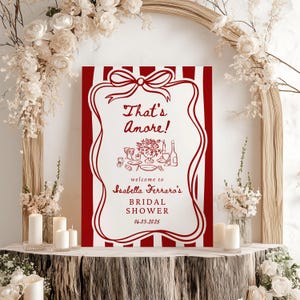 May include: Red and white striped bridal shower sign with the text "That's Amore!" and "Isabella Ferraro's Bridal Shower 06.03.2025".