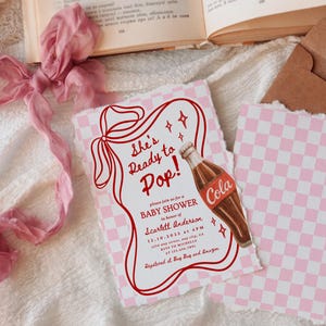 Puede incluir: Invitaci&oacute;n a un baby shower con un patr&oacute;n de cuadros rosas y blancos. La invitaci&oacute;n presenta el texto "She's Ready to Pop!" y una ilustraci&oacute;n de una botella de cola. El texto adicional incluye los detalles del baby shower.