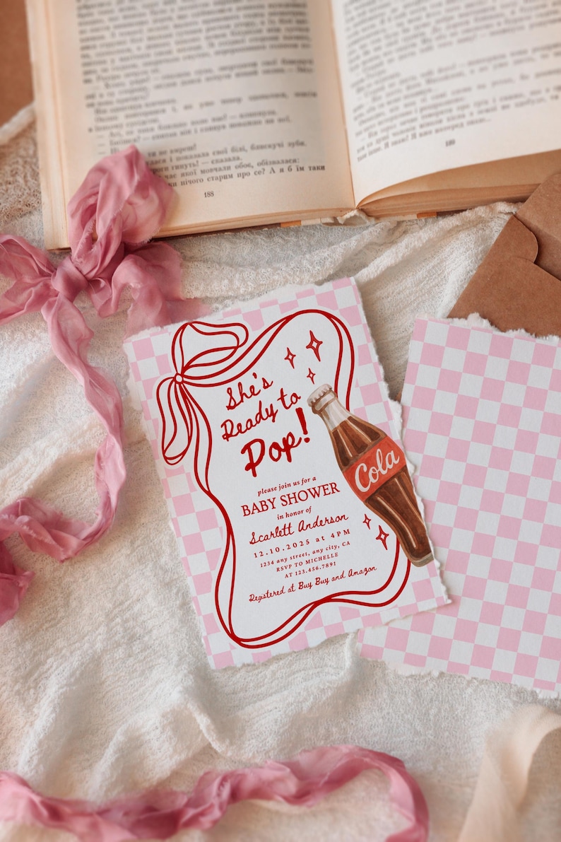 Puede incluir: Invitaci&oacute;n a un baby shower con un patr&oacute;n de cuadros rosas y blancos. La invitaci&oacute;n presenta el texto "She's Ready to Pop!" y una ilustraci&oacute;n de una botella de cola. El texto adicional incluye los detalles del baby shower.