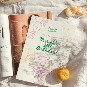 Może przedstawiać: Biała karta z zaproszeniem z zielono-r&oacute;żową ilustracją kobiety w kieliszku martini. Tekst na karcie brzmi "Cheers to Mariah!" i "Mariah's 30th Birthday!" z datą, miejscem i informacjami RSVP poniżej.