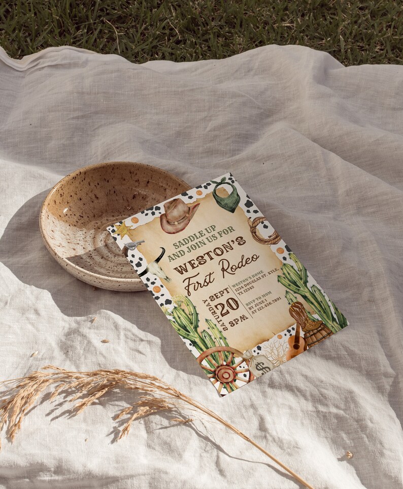 K&ouml;nnte beinhalten: Eine rustikale Einladung zu einem ersten Rodeo. Die Einladung zeigt einen Cowboyhut, Kakteen und ein Lasso. Der Text lautet "Saddle Up and Join Us for Weston's First Rodeo" mit Datum und Uhrzeit der Veranstaltung.