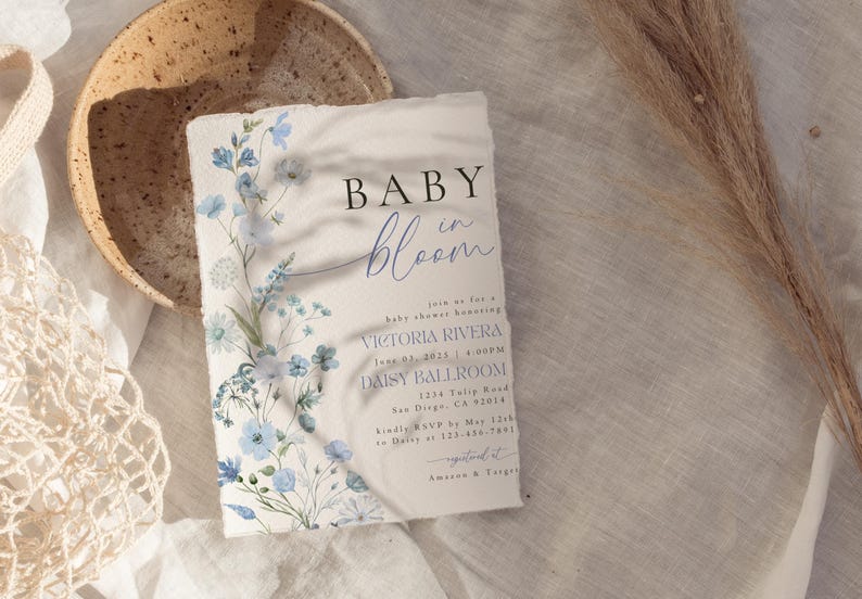 Puede incluir: Una invitaci&oacute;n a un baby shower con un dise&ntilde;o floral en tonos azules y blancos. La invitaci&oacute;n dice "Baby in Bloom" e incluye el nombre "Victoria Rivera" y la fecha "June 03, 2023".