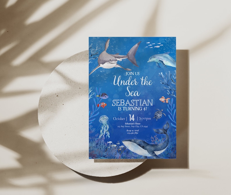 May include: A blue invitation card with an underwater theme. It features illustrations of a shark, dolphin, and other sea creatures. The text reads "Join Us Under the Sea, Sebastian is turning 4!" and includes the date and time.