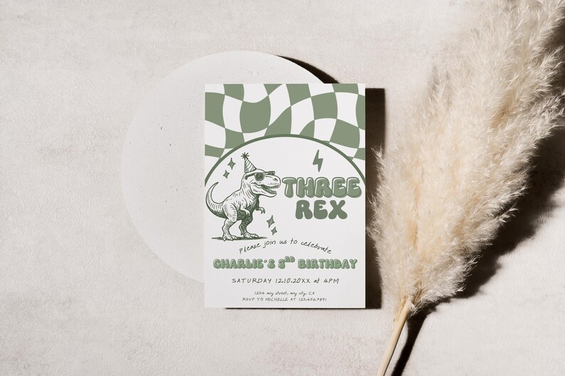 May include: A birthday invitation with a green and white checkered pattern at the top. The invitation features a cartoon dinosaur wearing sunglasses and a party hat, with the text "THREE REX". The invitation is for Charlie's 3rd birthday.