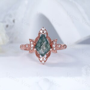 May include: A rose gold ring with a green moss agate gemstone set in a delicate, ornate design. The ring is accented with small, clear diamonds.