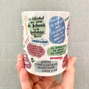May include: White ceramic mug with colorful text and illustrations. The text includes Spanish phrases and bible verses. The mug features phrases like "La felicidad que viene de Jehov&aacute; es mi fortaleza" and "Jehov&aacute; me conceder&aacute; los deseos de mi coraz&oacute;n."