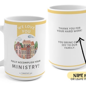 Peut inclure: Une tasse en c&eacute;ramique blanche avec une bande jaune et une illustration color&eacute;e de maisons. Le texte "WE LOVE YOU" est sur une banni&egrave;re jaune au-dessus des maisons. Le texte "FULLY ACCOMPLISH YOUR MINISTRY! 2. TIMOTHY 4:5" est sous les maisons. Le dos de la tasse a le texte "THANK YOU FOR YOUR HARD WORK! YOU BRING GREAT JOY TO OUR FAMILY." et un espace pour un nom.