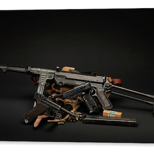 May include: A collection of firearms, including a submachine gun, pistols, and ammunition, is displayed against a black background. The submachine gun is prominent, with a long barrel and metal construction. Pistols are also present, with wooden grips. Ammunition is visible.