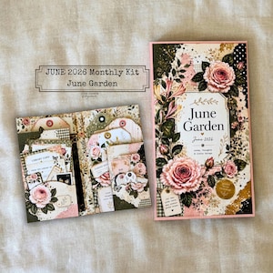 Può includere: Un kit mensile di giugno 2026, "June Garden", con un design floreale con rose rosa ed elementi decorativi. Il kit include un diario e un libretto con tag e carte, il tutto con un'estetica vintage.