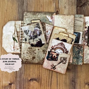 Könnte beinhalten: A Study of Things Junk Journal Folio Kit. Dieses Journal im Vintage-Stil verfügt über eine Vielzahl von dekorativen Papieren, Taschen und Tags. Das Kit enthält Bilder von Schmetterlingen, Uhren und Schlüsseln, mit einer neutralen Farbpalette aus Beige, Braun und Creme.