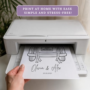 May include: A white printer printing a black and white wedding car design on paper. The design includes the words "Just Married" and the names "Olivia & Alex" with a date. Text at the top reads "PRINT AT HOME WITH EASE SIMPLE AND STRESS-FREE!"