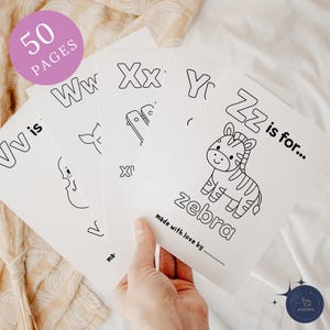 Puede incluir: Un montón de páginas para colorear blancas con contornos negros de letras e ilustraciones. Las páginas incluyen las letras W, X, Y y Z, con una ilustración de cebra para la letra Z. El texto "50 PAGES" está en un círculo rosa.