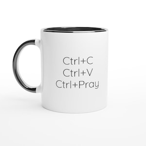 May include: A white ceramic mug with a black interior and a black handle. The exterior features black text that reads Ctrl+C, Ctrl+V, and Ctrl+Pray, arranged in three vertical lines on the side of the mug.