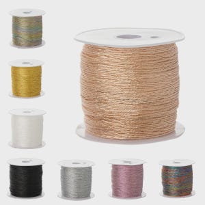 Puede incluir: Una variedad de carretes de hilo en varios colores, incluyendo dorado, blanco, negro, plateado y rosa. El hilo está enrollado firmemente en carretes de plástico blanco, adecuado para manualidades y costura.