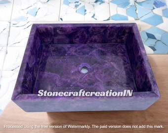 May include: A rectangular purple stone sink with a drain hole. The sink has a polished surface with a marbled appearance. The text "StonecraftcreationIN" is visible on the front of the sink.