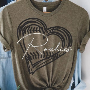 Puede incluir: Camiseta verde oliva con un gráfico de corazón de béisbol negro y el texto "Rockies" en blanco.
