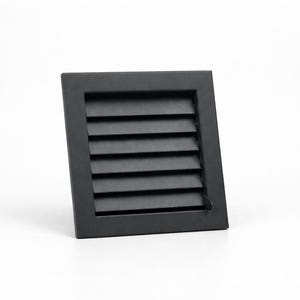 Può includere: Un coperchio di ventilazione quadrato nero con lamelle orizzontali. Il coperchio è posto su uno sfondo bianco. Il telaio è quadrato e le lamelle sono distanziate in modo uniforme, creando un aspetto pulito e moderno.