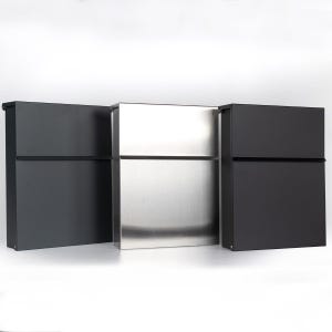 May include: Three contemporary mailboxes. The mailboxes are rectangular with a horizontal slot and a hinged door. The mailboxes are in a row, with black mailboxes on either side of a stainless steel one.