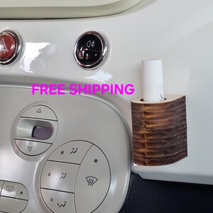 May include: A wooden car air freshener with a brown and white striped design. The air freshener is attached to the dashboard of a white car. The text "FREE SHIPPING" is visible in the image.