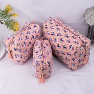 Può includere: Tre pochette per cosmetici con cerniera di diverse dimensioni, con motivo floreale rosa e blu.