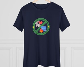 Könnte beinhalten: Ein marineblaues T-Shirt mit einem grünen Kreis-Motiv, auf dem steht "Wir testen nicht an Tieren. Wir testen in der Produktion." Das Motiv enthält auch ein durchgestrichenes Kaninchen, ein Herz, einen Server und eine Flamme.