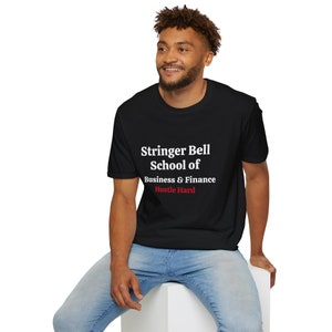 May include: A black t-shirt with white text that reads "Stringer Bell School of Business & Finance Hustle Hard". The text "Hustle Hard" is in red.