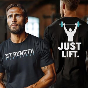 May include: Black t-shirt with white text that says "Strength Redefined" on the front and "Just Lift" with a silhouette of a person lifting weights on the back.
