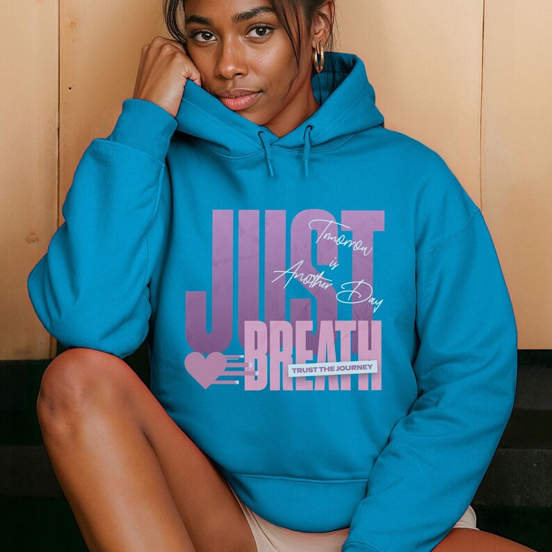 May include: A turquoise hoodie with the words "JUST BREATHE" in a purple and pink design. The text "Tomorrow is Another Day" and "TRUST THE JOURNEY" are also featured on the front of the sweatshirt.