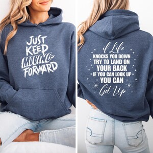 May include: A navy blue hoodie with the text "Just Keep Moving Forward" on the front and "If life knocks you down try to land on your back. If you can look up you can get up" on the back.