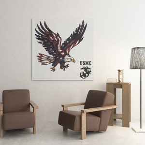 Pu&ograve; includere: Una stampa su tela con un'aquila calva americana con il design della bandiera americana sulle ali. L'aquila sta volando con le ali spiegate. La stampa include anche il logo USMC con le parole "USMC" sopra. La stampa &egrave; appesa a un muro bianco sopra un divano marrone.