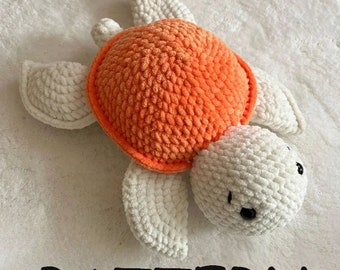 May include: A crocheted orange and white turtle toy. The turtle has a round orange shell and white limbs and head. The head has two black eyes.