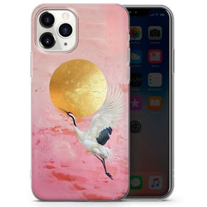 Peut inclure: Une coque de t&eacute;l&eacute;phone rose et or avec une grue blanche volant devant un soleil dor&eacute;. La coque est con&ccedil;ue pour un iPhone.