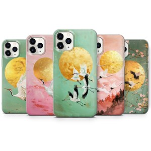 Peut inclure: Ensemble de cinq coques de t&eacute;l&eacute;phone avec un design d'inspiration japonaise avec une lune dor&eacute;e et des grues blanches volant sur un fond vert, rose ou bleu.