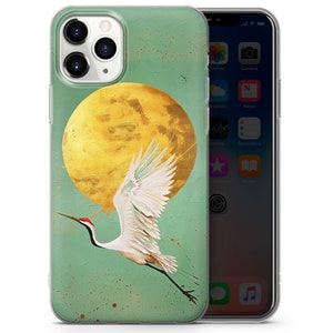 Peut inclure: Une coque de t&eacute;l&eacute;phone verte avec une grue blanche volant devant une lune jaune. La coque a un fond textur&eacute; avec des points blancs.