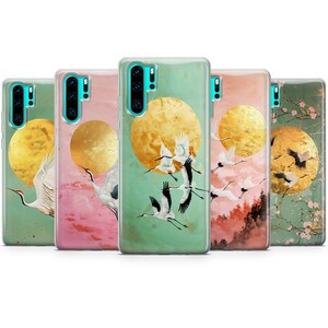 Peut inclure: Cinq &eacute;tuis de t&eacute;l&eacute;phone diff&eacute;rents avec un design d'inspiration japonaise repr&eacute;sentant une lune dor&eacute;e et des grues blanches volant devant elle. Les &eacute;tuis ont un fond vert, rose et bleu.