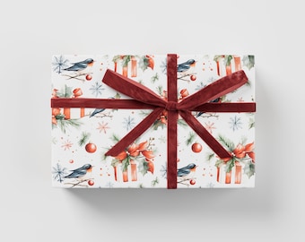 Könnte beinhalten: Eine weiße Geschenkbox mit rotem Band und Schleife. Die Box ist in Papier mit einem Muster aus Vögeln, Schneeflocken und Stechpalmen eingewickelt.