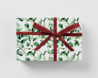 May include: A white gift box with a red velvet ribbon tied in a bow. The box is wrapped in white paper with a green and white floral pattern.