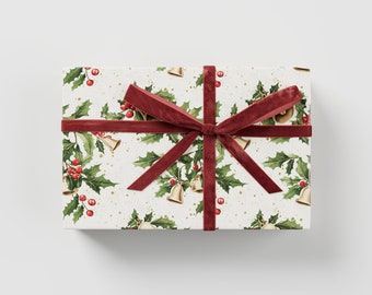May include: A white gift box with a red ribbon and a Christmas-themed wrapping paper featuring holly leaves, red berries, and gold bells.