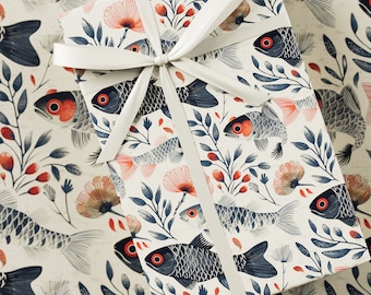 May include: A white gift wrap with a repeating pattern of blue and black fish, red flowers, and green leaves. The gift wrap is tied with a white ribbon.