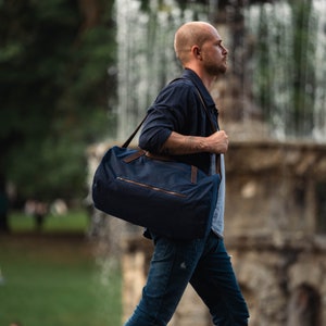 Weekender carried on the shoulder by walking man