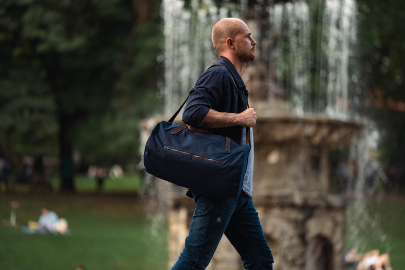 Weekender carried on the shoulder by walking man