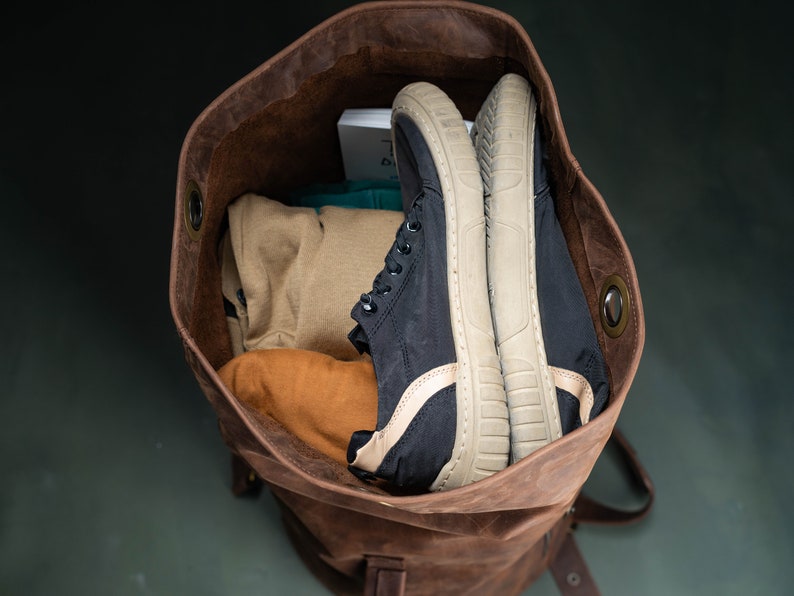 A duffel bag seen from above, with clothes and a pair of shoes inside.