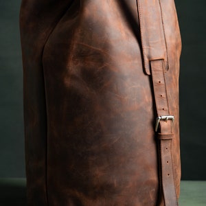 The shoulder strap of a leather duffel bag.