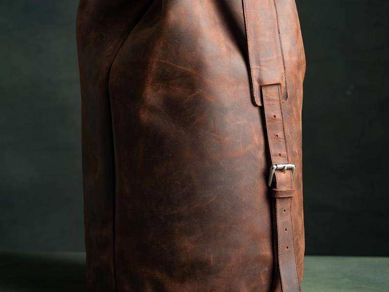 The shoulder strap of a leather duffel bag.