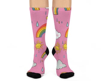 Könnte beinhalten: Rosa kniehohe Socken mit einem sich wiederholenden Muster aus Regenbogen, lächelnden Sonnen, Wolken und Regentropfen. Die Socken haben schwarze Fersen und Zehen. Das Design ist farbenfroh und skurril.