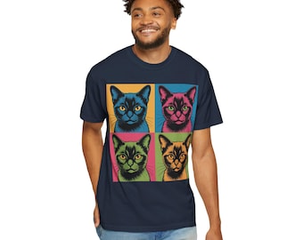 May include: Navy blue t-shirt featuring a pop art design of four cats with different colored eyes and backgrounds. The cats are in blue, pink, green, and orange squares. The shirt is a casual wear item.