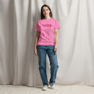 May include: A pink t-shirt with the text "What fresh hell is this?" printed in red.